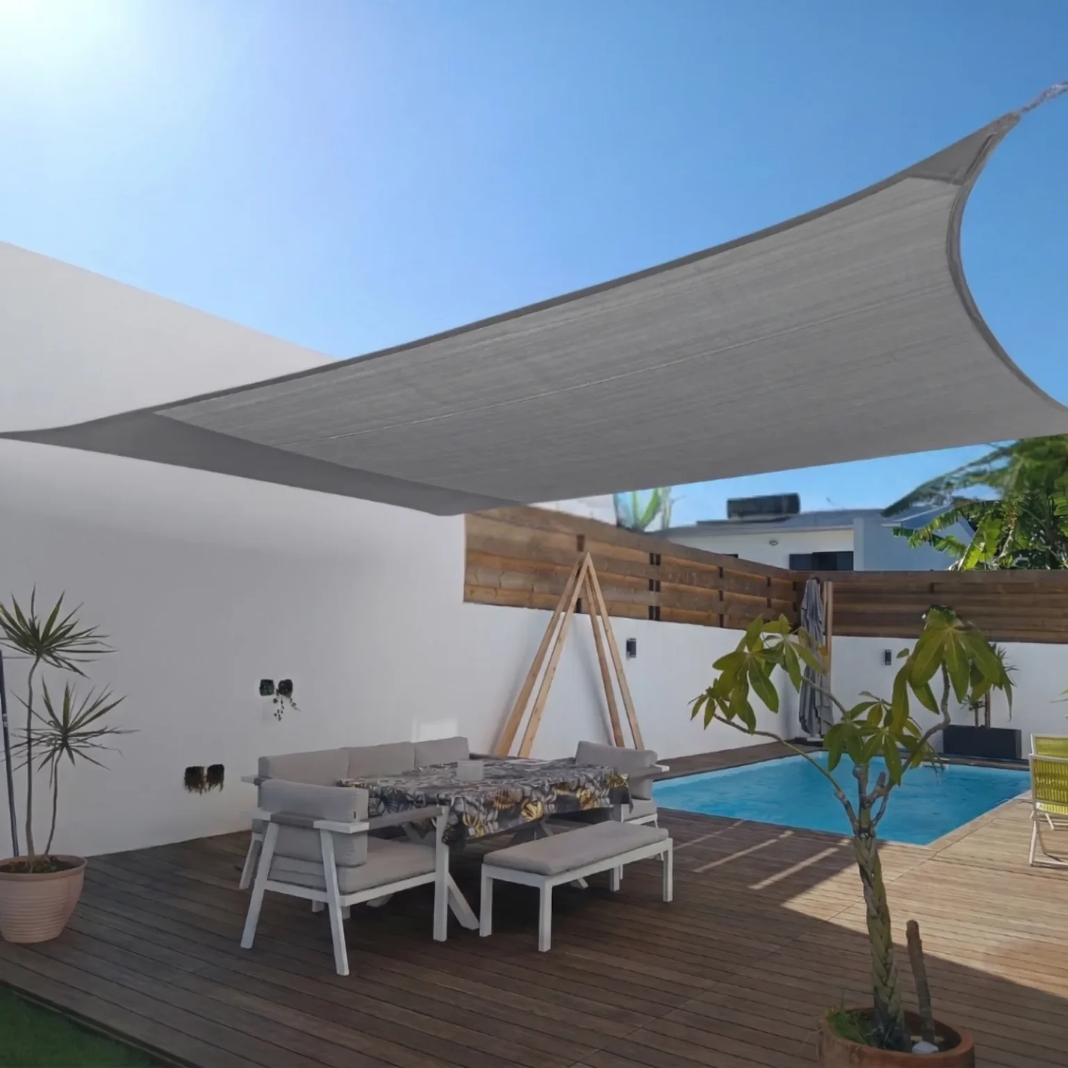 Voile d'ombrage gris 220g installée sur une terrasse en bois avec piscine à La Réunion